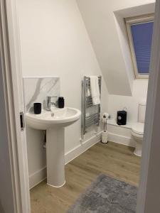 a white bathroom with a sink and a toilet at Modern Stay - Walk to Everything 6 in Ipswich