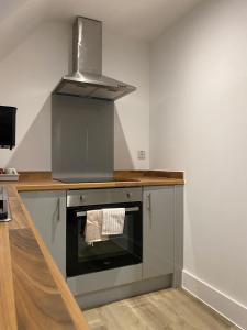 a kitchen with a stove top oven with a hood at Modern Stay - Walk to Everything 6 in Ipswich