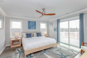 ein Schlafzimmer mit einem Bett und einem Deckenventilator in der Unterkunft Sojourn Dune Cottage Beach Front Bliss 3 BR 3 BA in Norfolk