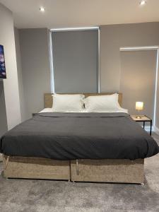 a bedroom with a large bed with a large window at Chic Maidstone getaway in Maidstone