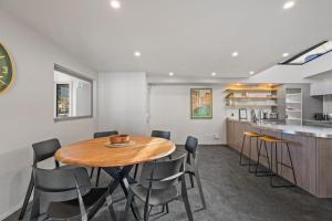 a kitchen and dining room with a wooden table and chairs at Cecil Peak View Apartment in Queenstown