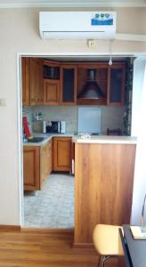 kuchnia z drewnianymi szafkami i otwartymi drzwiami w obiekcie Apartment Karamzina 43 w mieście Noworosyjsk