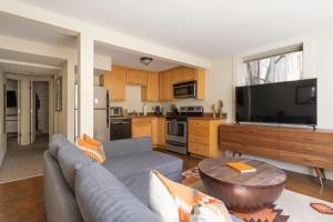 a living room with a couch and a large television at Desert Vibe 1BR in SE PDX - Local Bars & Food in Portland