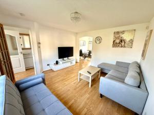 a living room with a couch and a tv at Kings Meadows Luxury Home - Free Parking and SuperFast WiFi in Edinburgh