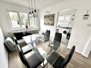 a living room with a glass table and chairs at Kings Meadows Luxury Home - Free Parking and SuperFast WiFi in Edinburgh +22 photos