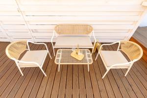 two wicker chairs and a table on a porch at Schinosa 30 luxury room in Bisceglie