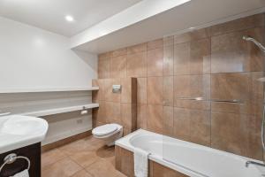 a bathroom with a tub and a toilet and a sink at Cecil Peak View Apartment in Queenstown +15 photos