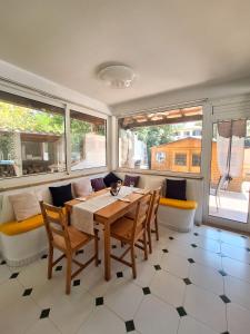 una sala da pranzo con tavolo, sedie e finestre di Villa Nevada Gran casa vacacional familiar con piscina cerca de la playa en Puerto Pollença a Port de Pollença