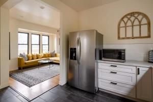 a kitchen with a stainless steel refrigerator and a living room at Charming SE Home - Farmhouse Style - Remodeled in Portland