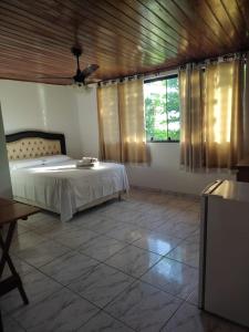 a bedroom with a bed and a ceiling fan at Suites Rei da Moqueca in Angra dos Reis