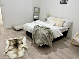 a bedroom with a bed with a blanket and a rug at The Botanica, Stylish Edgbaston Escape with Garden Charm in Birmingham +8 photos