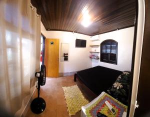 a living room with a couch and a room with a tv at Pousada do Arthur in Ilha do Mel