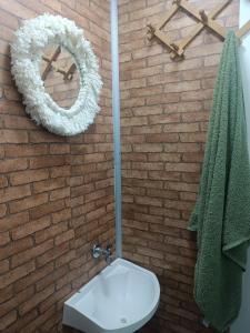 a bathroom with a white toilet and a brick wall at Treiler experiência na floresta in Iomerê