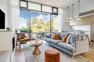 a living room with a couch and a table at Luxurious Penthouse - Park, Golf Course, Ocean views in Collaroy