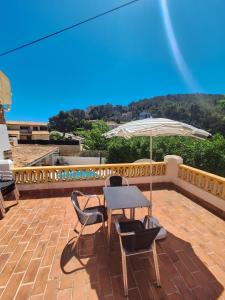 un tavolo, sedie e un ombrellone in un patio di Villa Nevada Gran casa vacacional familiar con piscina cerca de la playa en Puerto Pollença a Port de Pollença