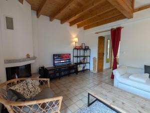 a living room with a white couch and a tv at Chalet chaleureux à Gérardmer, vue pistes, 4 pers. - FR-1-589-371 in Gérardmer