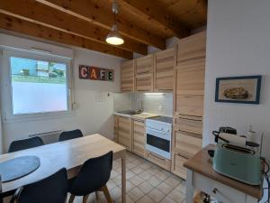 a kitchen with wooden cabinets and a table and chairs at Chalet chaleureux à Gérardmer, vue pistes, 4 pers. - FR-1-589-371 in Gérardmer