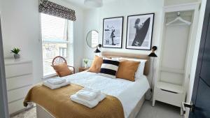 a bedroom with a bed with two towels on it at Sandy Beaches Portrush - Steps from Beach & Dining in Portrush