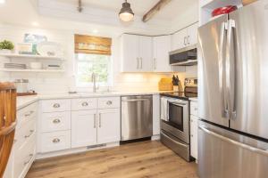 a kitchen with white cabinets and a stainless steel refrigerator at Heaven on Earth 2 BDR Fontana Flat Walk to Lake in Lake Geneva +30 photos