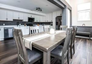 Una cocina con una mesa y sillas de madera. en The Greystone - Stay for 12, en Lake Geneva