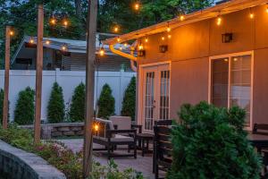 Un patio con mesa, sillas y luces. en The Greystone - Stay for 12, en Lake Geneva