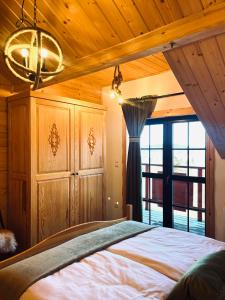 a bedroom with a bed and a large window at Apartamenty Kowolówka Koniaków in Koniaków