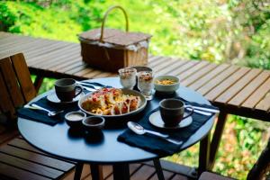 une table bleue avec une plaque de nourriture dans l'établissement EcoLodge a casinha da floresta, à Morro de São Paulo