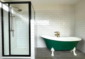 bagno con vasca verde e doccia di Phillip Island Coastal Cabins a Sunderland Bay Altre 41 foto