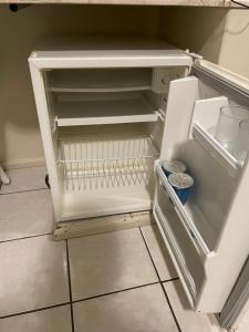 an empty refrigerator with its door open in a kitchen at Hotel Praia Brava in Florianópolis