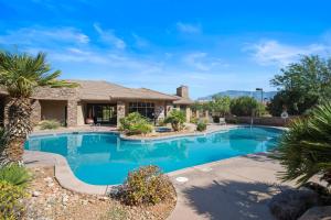 a swimming pool with a palm tree and a house at Sierra Sky - Patio with fireplace in Hurricane