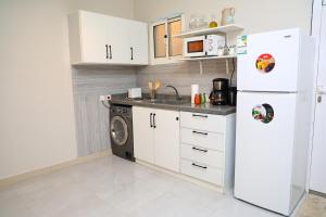 Una cocina con un frigorífico blanco y un lavavajillas. en Ample one-bedroom Apartment, en Riad