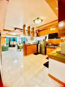 a large kitchen with wooden cabinets and a large room at Lens Staycation 3BDR-2BR-Downstairs ,NetflixWifi in Panabo