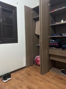 a closet with a door and some shoes in it at Recanto azul in Araranguá