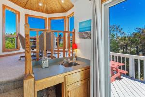 Il dispose d'une cuisine avec un évier et d'un balcon avec une table. dans l'établissement 1300 - Shore Pleasure, à Corolla