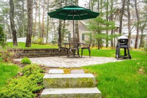 a patio with a table and an umbrella in a yard at Beachside Oceanside Walk onto the beach in Saco