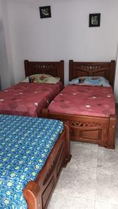 two beds sitting next to each other in a room at Hotel Isla Capri in Mompos