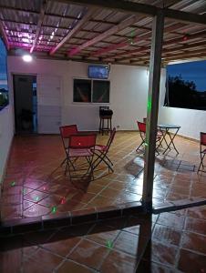 a room with chairs and a table on a patio at Hotel Isla Capri in Mompos