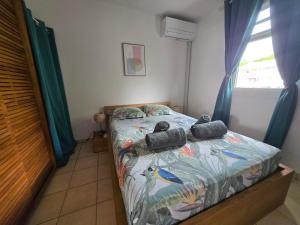 une chambre avec un lit avec une couette à motifs d'oiseaux dans l'établissement L'Oiseau de Paradis - Vue Mer Panoramique, à Les Trois-Îlets