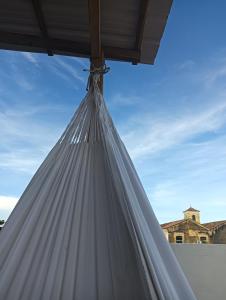 a white curtain hanging from a patio umbrella at Hotel Isla Capri in Mompos