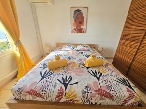 une chambre avec un lit avec une couette colorée dans l'établissement L'Oiseau de Paradis - Vue Mer Panoramique, à Les Trois-Îlets