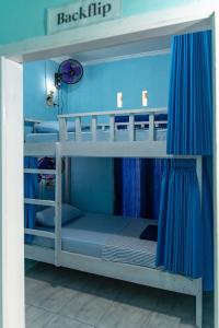 a bedroom with two bunk beds with blue walls at Ekas Loka Surf Hostel in Ekas +9 photos