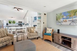 a living room with a table and chairs and a kitchen at 1689 - Maison de la Mer in Poplar Branch