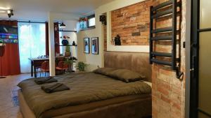 a bedroom with a bed and a brick wall at Lyva Portus in Grobiņa +17 photos