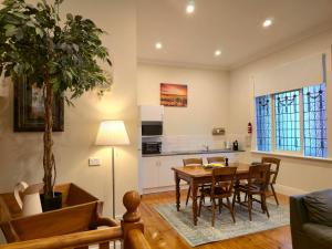 a kitchen and dining room with a table and chairs at Tanunda Central Cottage in Tanunda