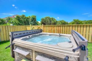 una bañera de hidromasaje en un patio trasero con una valla en 4056 - Tight Lines Tan Lines, en Playa de Kitty Hawk
