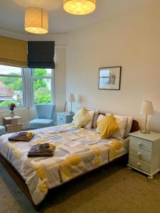 Un dormitorio con una cama grande con almohadas amarillas. en Caroline's House, en Swanage