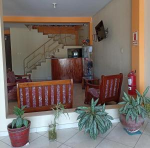 a living room with two benches and a staircase at Hospedaje Momentos in Tarapoto