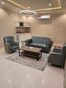 a living room with two chairs and a couch and a table at Rove Appartments in Taif