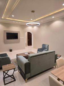 a living room with a couch and chairs and a tv at Rove Appartments in Taif +7 photos