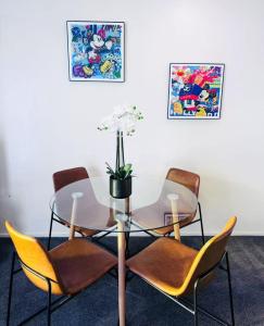 a glass table with chairs and a table with a plant on it at Merivale Court Family Suit-Unit 4 in Christchurch